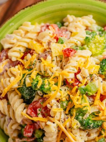 rotini pasta salad with broccoli and cheddar on a green plate