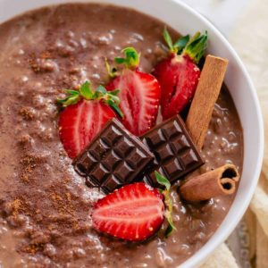 close up image of chocolate rice pudding with strawberries and miniature chocolates.