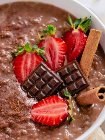 close up image of chocolate rice pudding with strawberries and miniature chocolates.