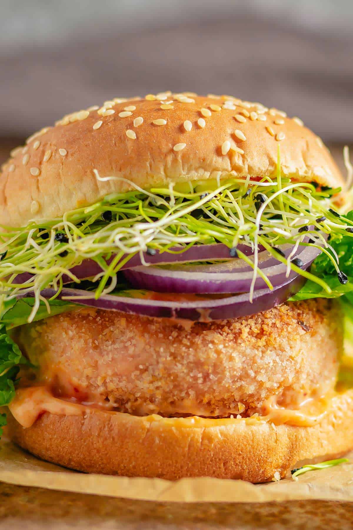 salmon burger with lettuce and red onion with sesame buns