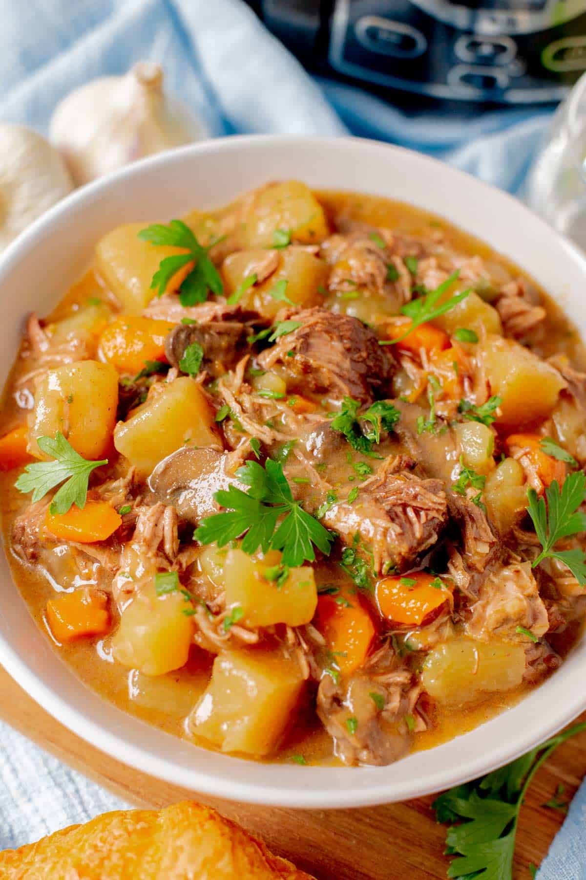 slow cooker beef stew with mushrooms is erved in a white bowl