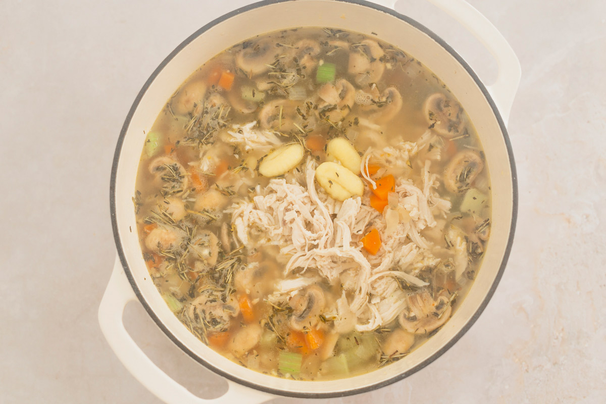 creamy gnocchi chicken soup in a white pot before adding spinach