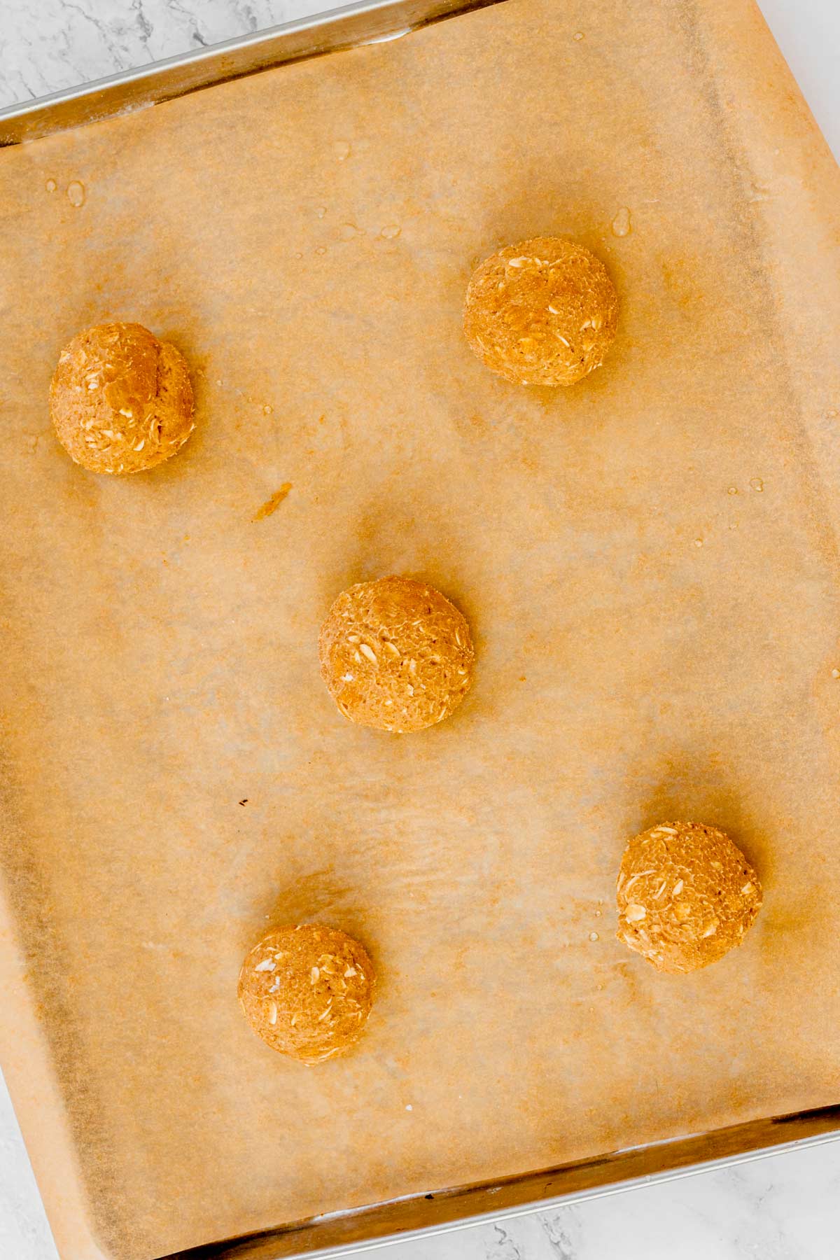 pumpkin cookie balls before baking on a baking sheet