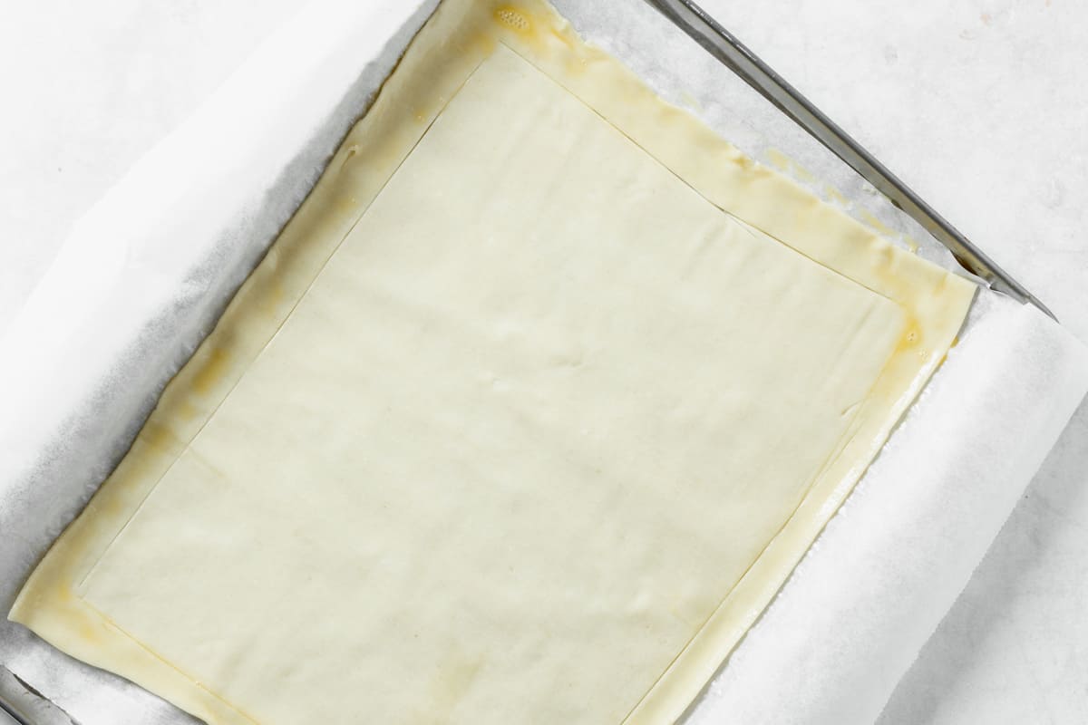 puff pastry rolled out on baking sheet