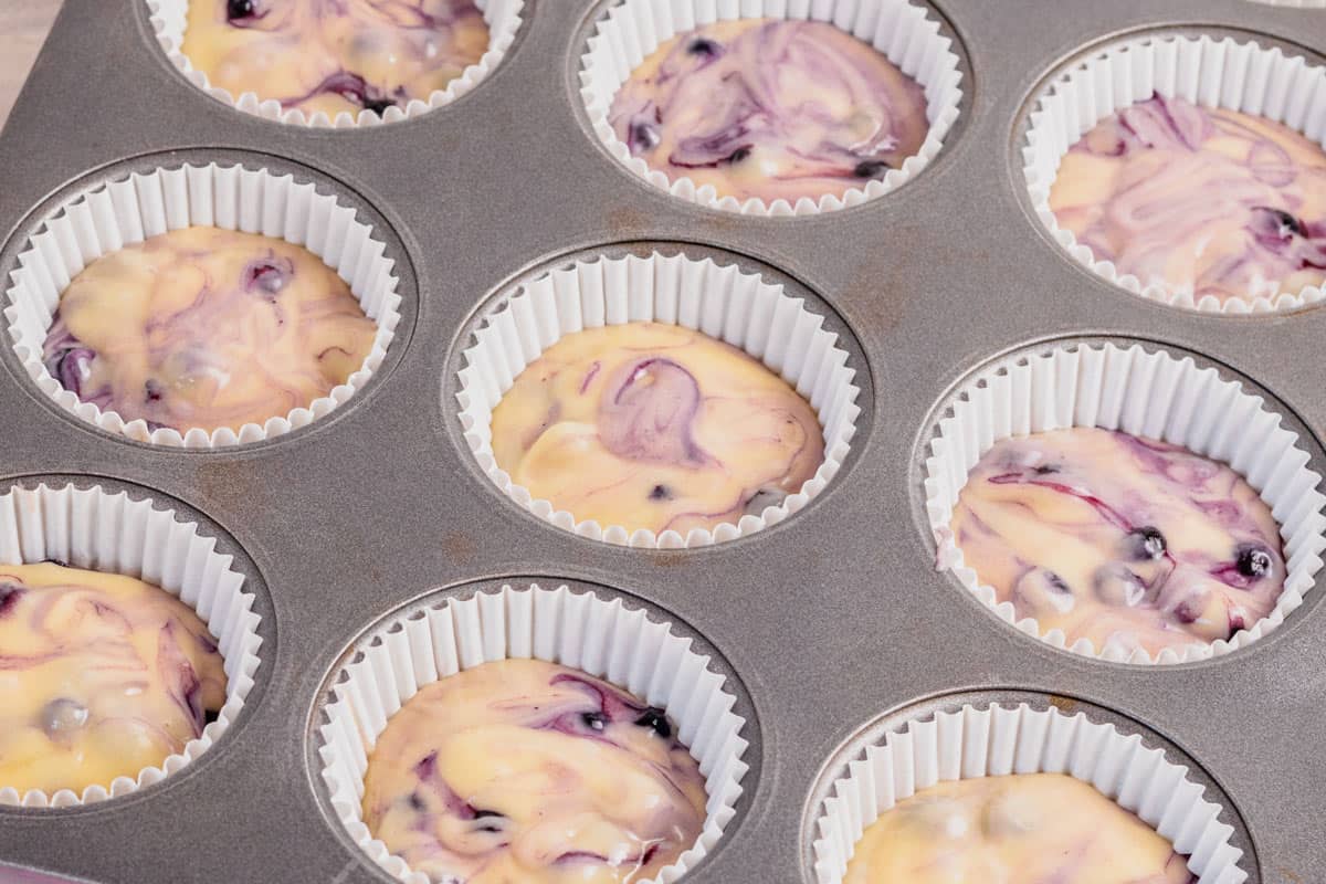 blueberry muffin batter in muffin tins