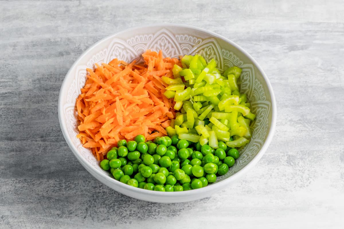 carrots, celery and peas in a bowl for hawaiian mac