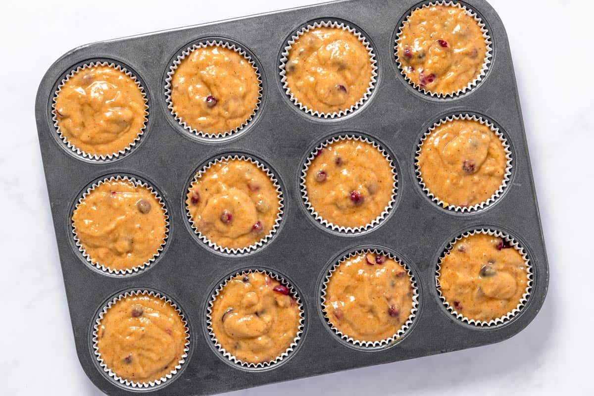 pumpkin muffin batter poured into muffin tins