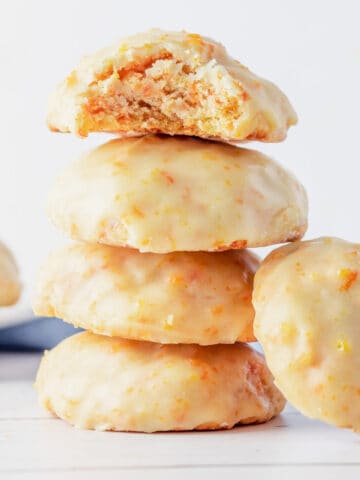 a stack of carrot cookies with orange icing