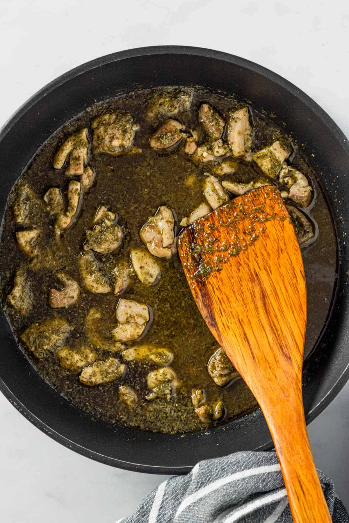 cooking chicken pieces in skillet.