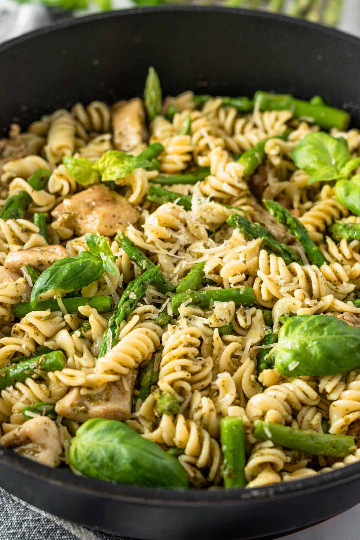 side view shot of fusilli pasta with asparagus and chicken.