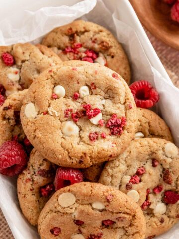a stack of raspberry cookies with white chocolate chips in baking dish