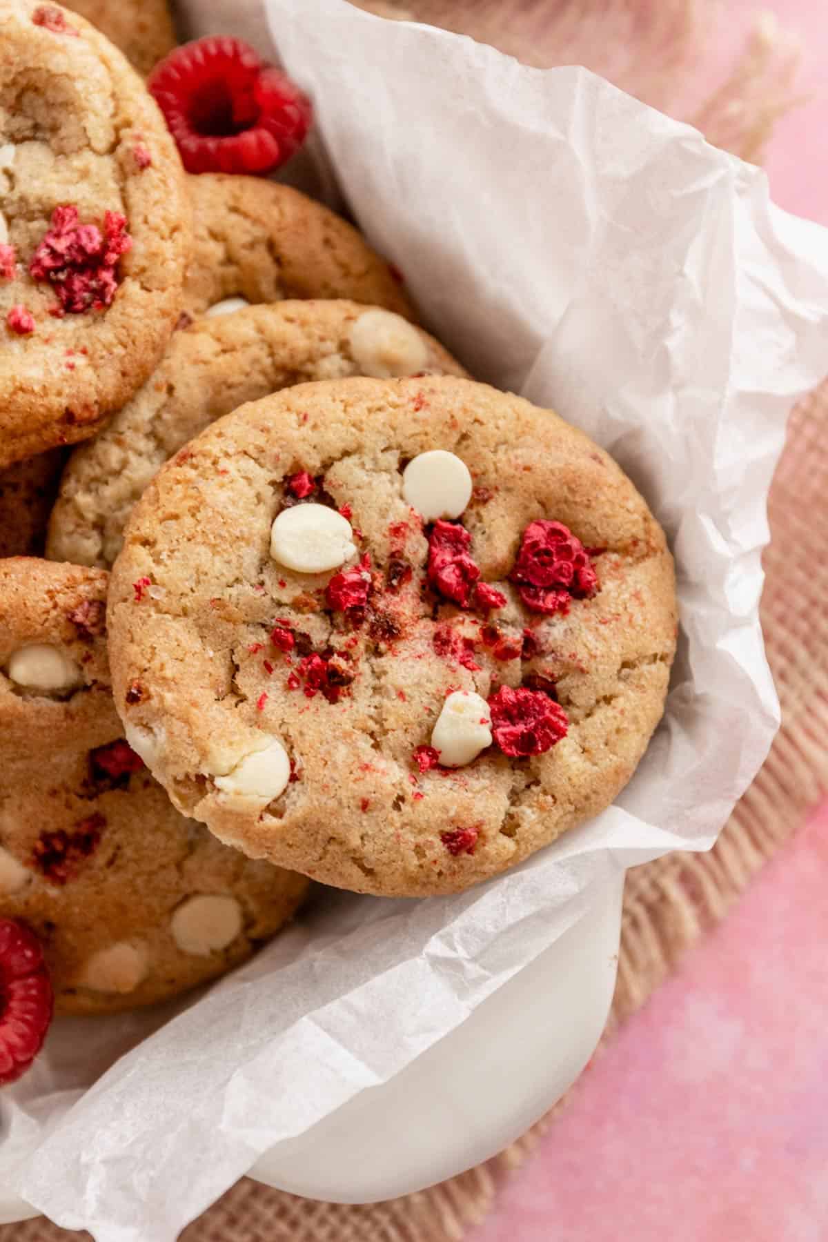 a stack of raspberry cookies with white chocolate chips in baking dish