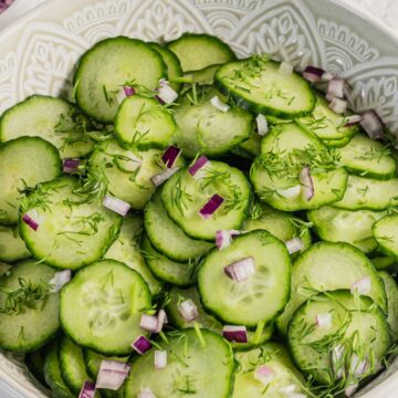 fresh cucumber dill salad in a bowl with red onion and dressing