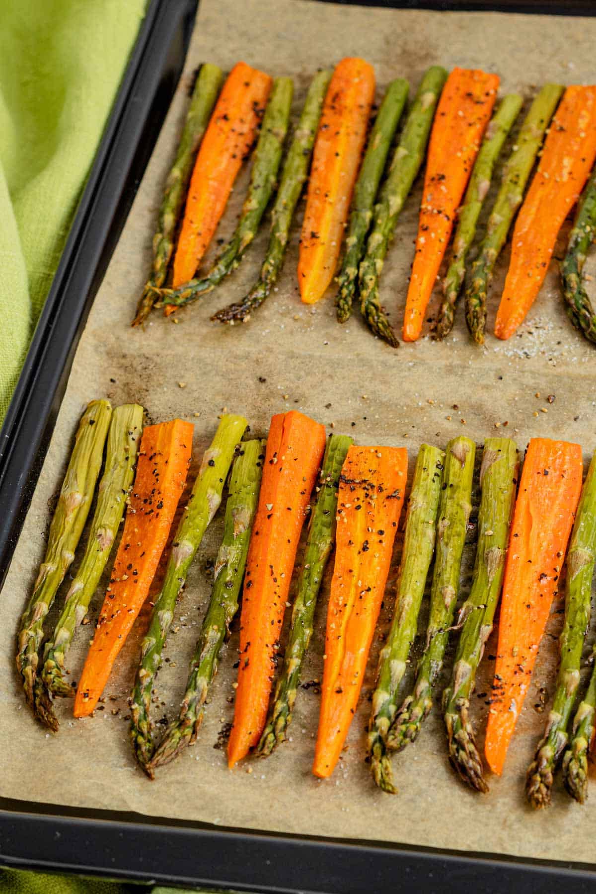 asparagus in the oven with carrots on a baking sheet