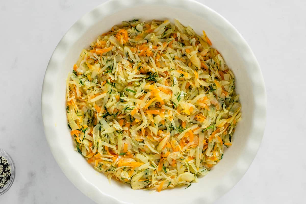 shredded cabbage and carrots in rounded cake pan