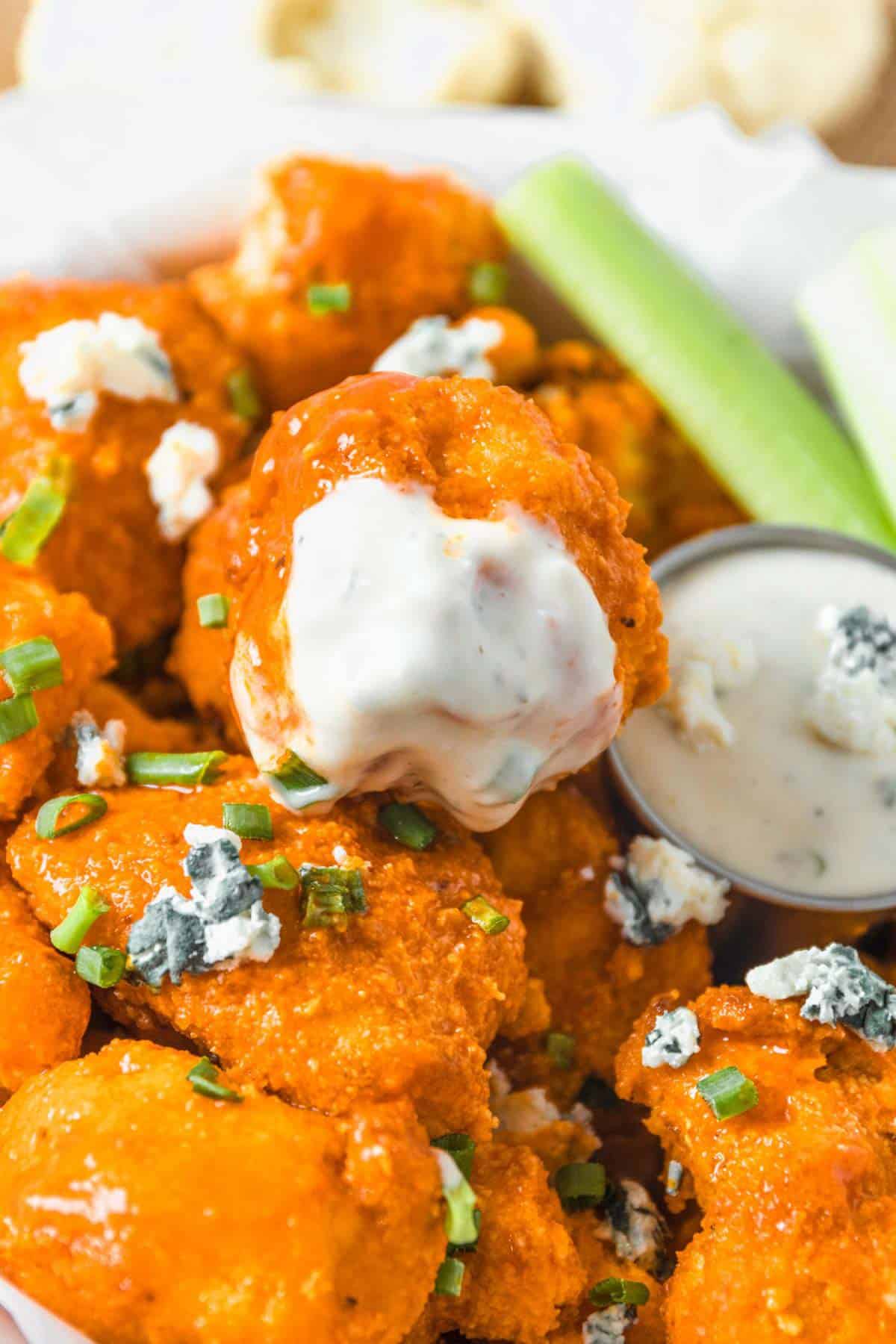buffalo cauliflower bites stacked together in a bowl.
