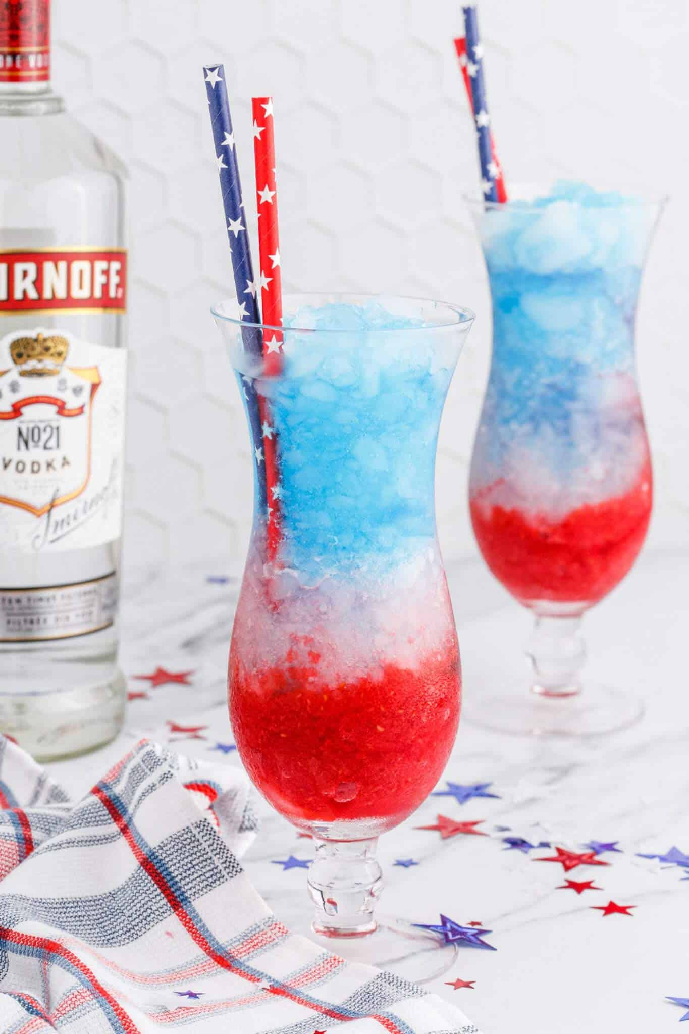 patriotic colorful layered vodka lemonade slushies in tall glasses.