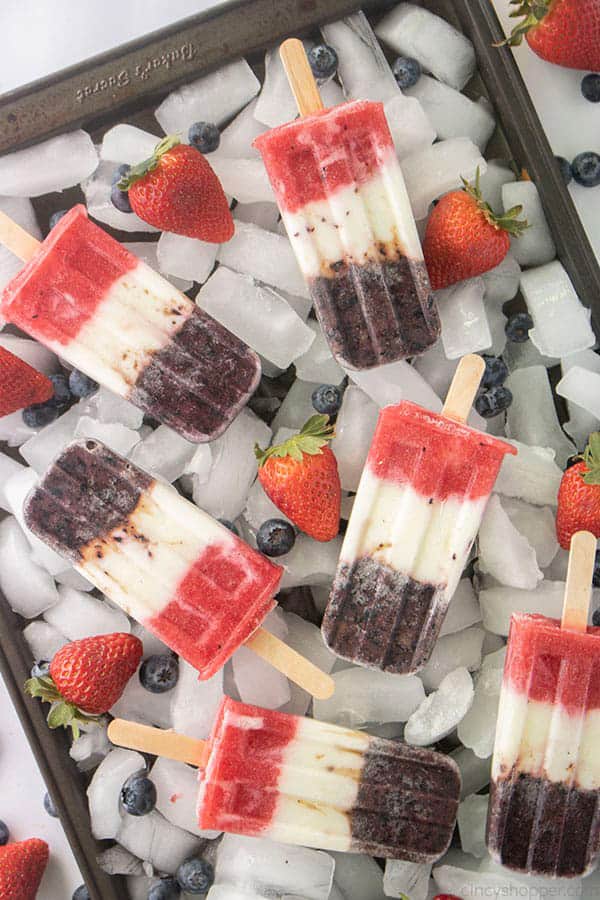 red, white, blue popsicles scattered on ice cubes.