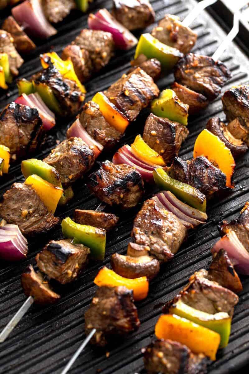 multiple steak kebabs on skewers.