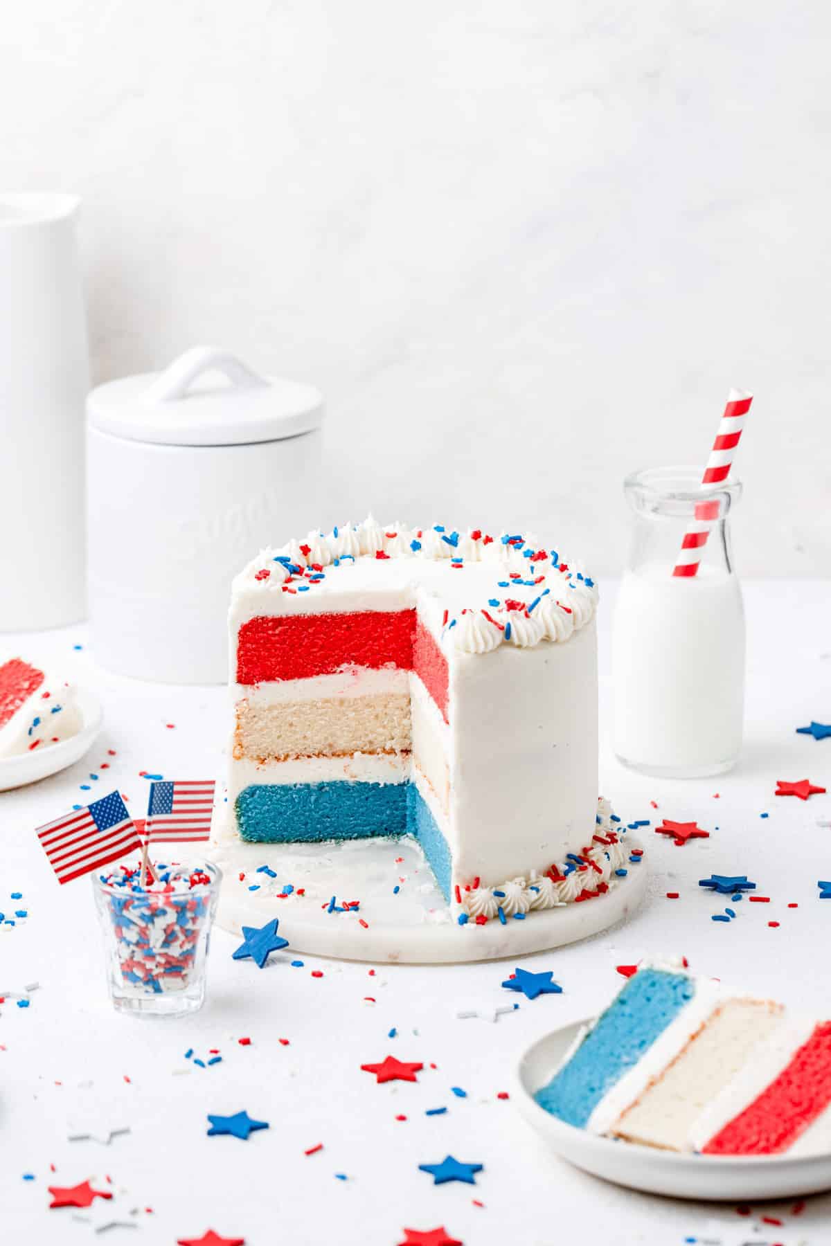 red, white and blue layer cake with a slice cut out.