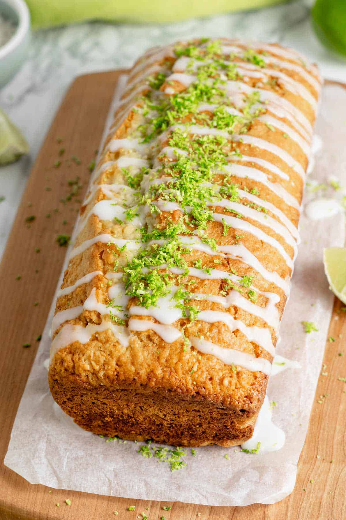 coconut lime loaf cake with icing sugar and lime zest on top.