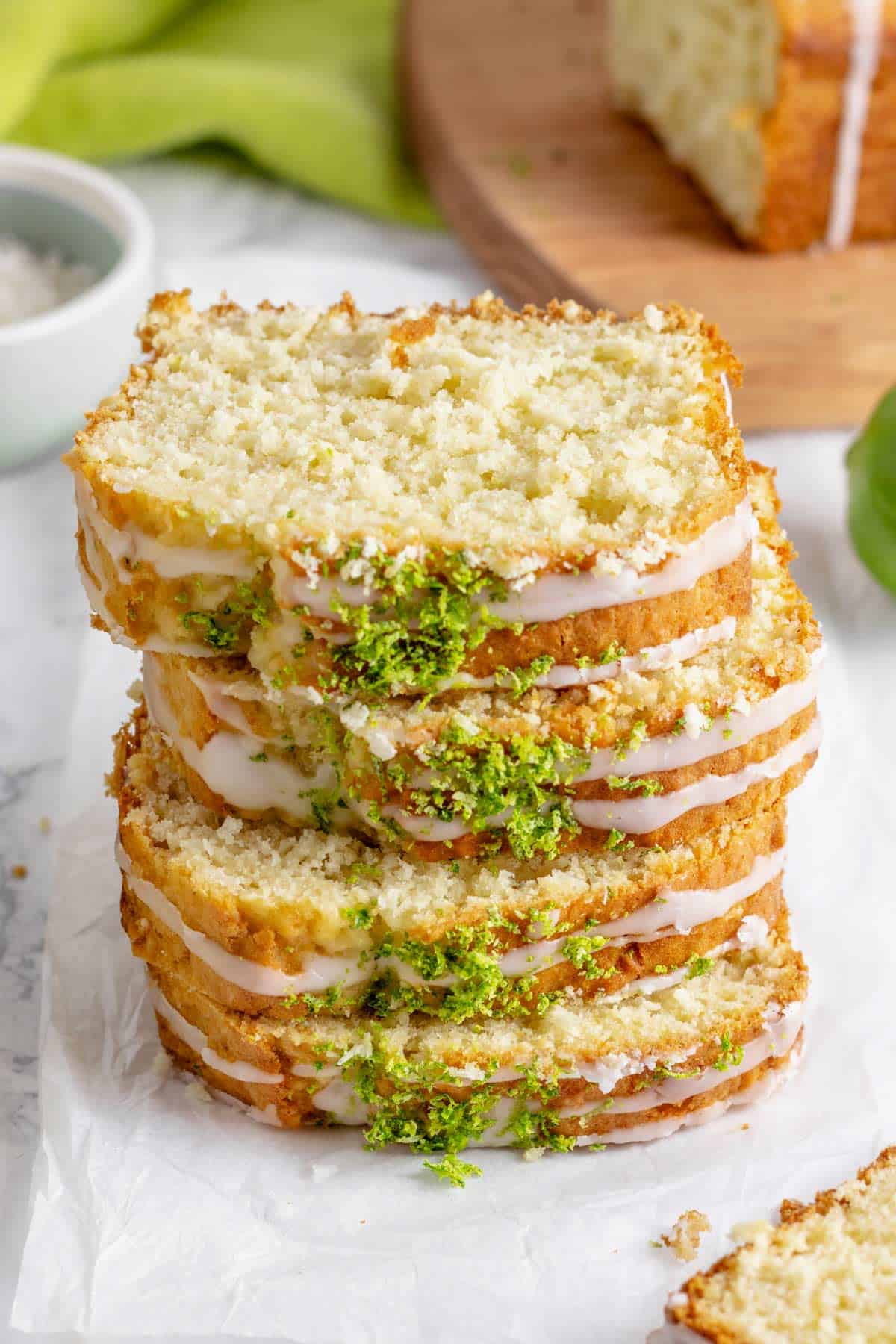 a stack of slices coconut lime loaf cake.