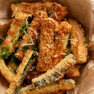 almond flour breaded zucchini fries in a bowl with grated parmesan.