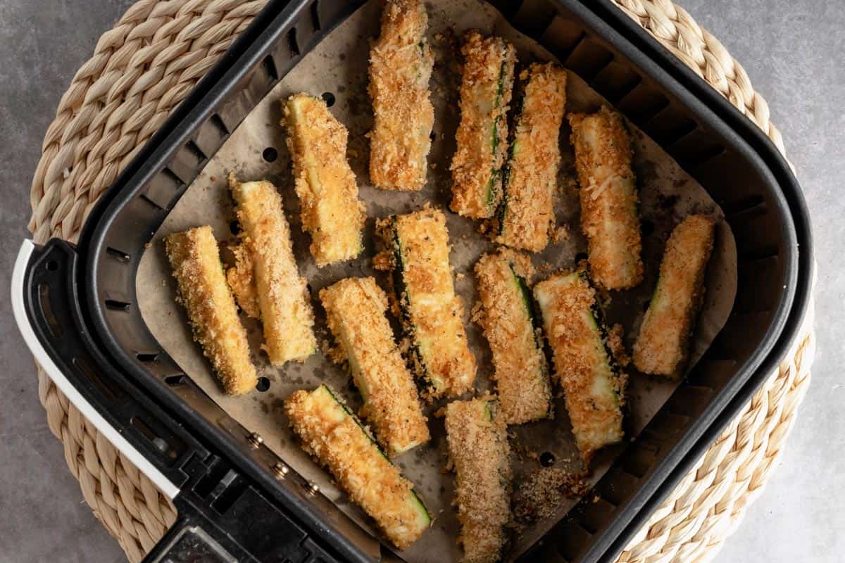 zucchini fries in air fryer basket before cooking.