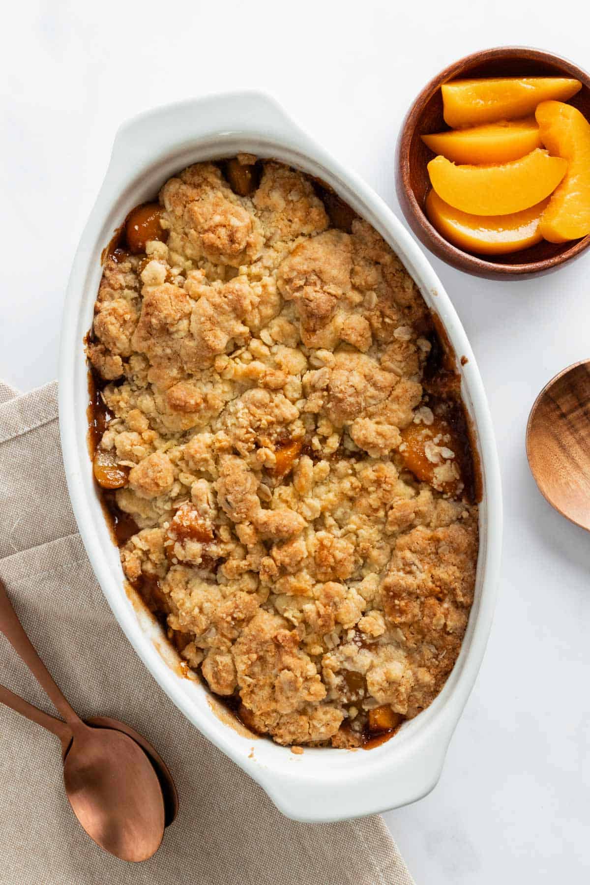 peach cobbler with golden brown topping in casserole dish.