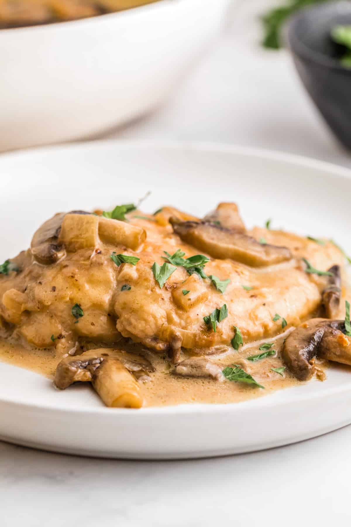 a piece of chicken breast coated in mushroom sauce on a plate.
