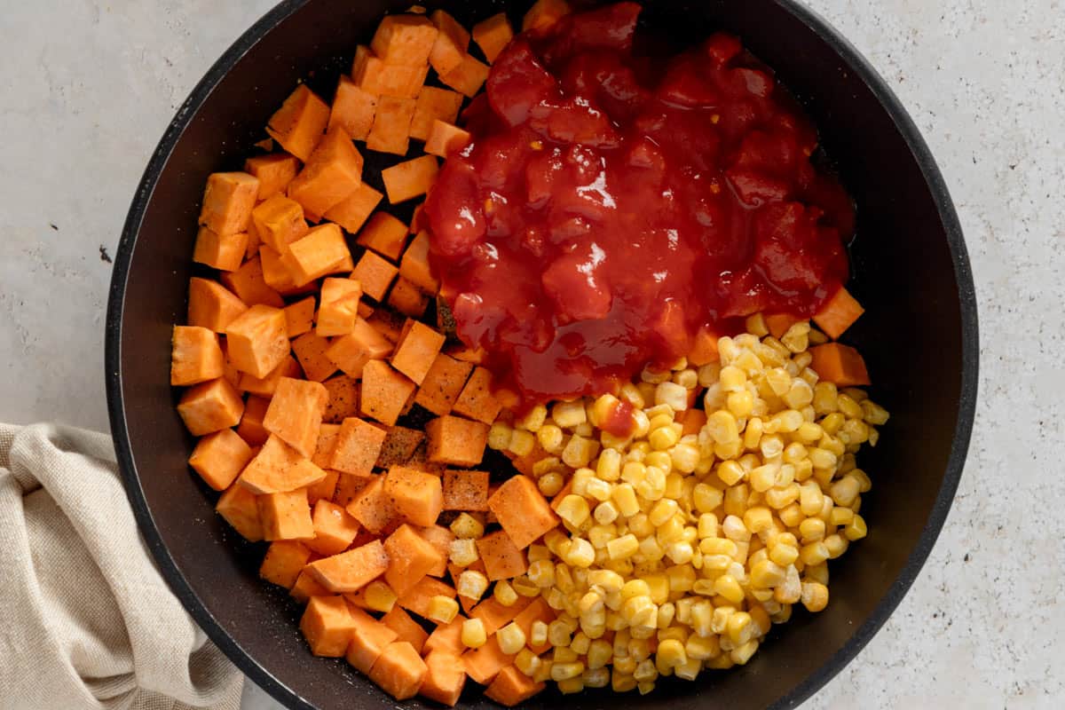 sweet potato cubes, corn and diced tomatoes added to skillet.