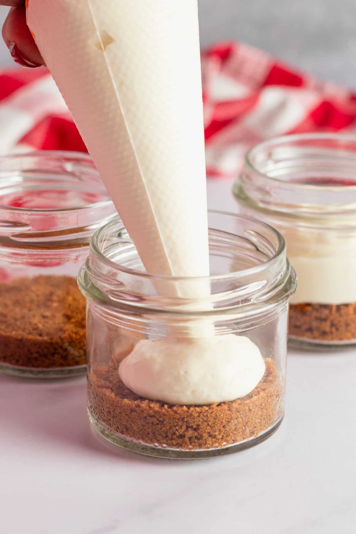 piping cream cheese layer into jars.