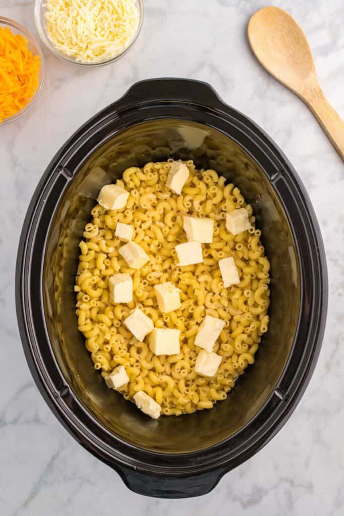 butter cubes added to pasta in slow cooker.