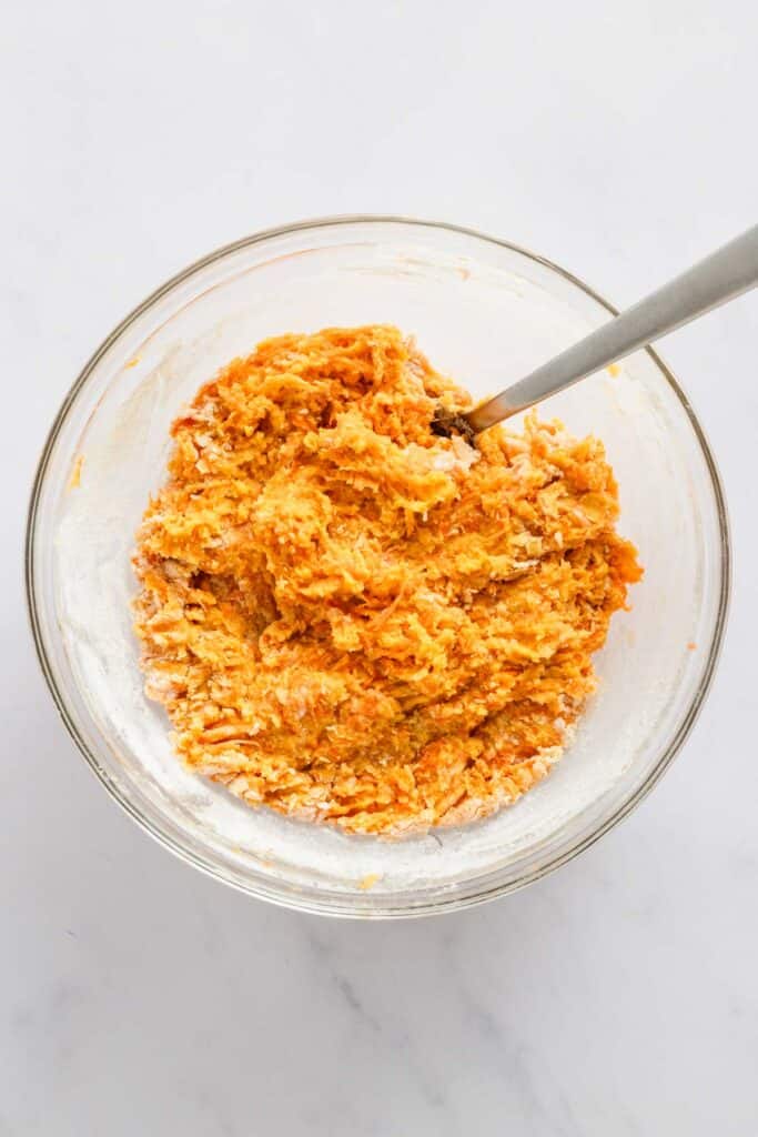 grated carrots in a bowl with batter.