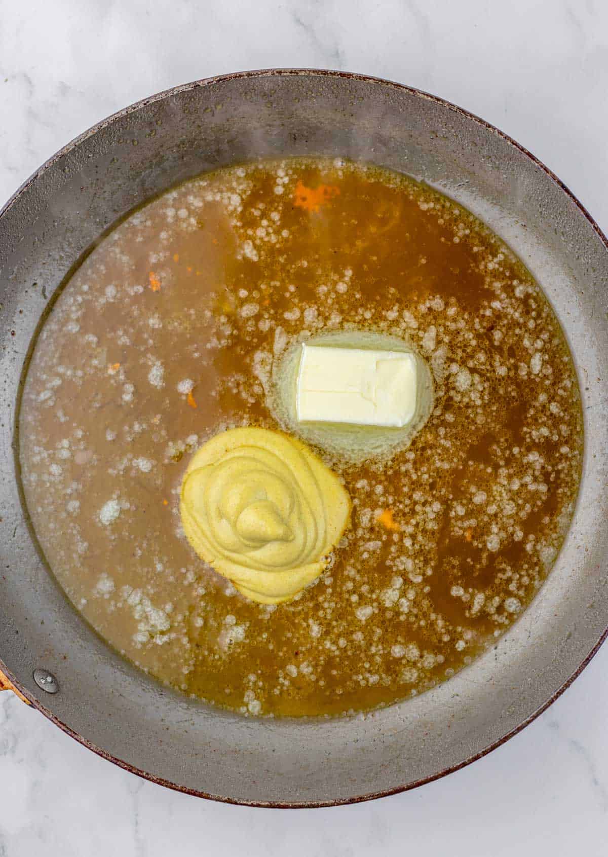 making lemon butter sauce in skillet.