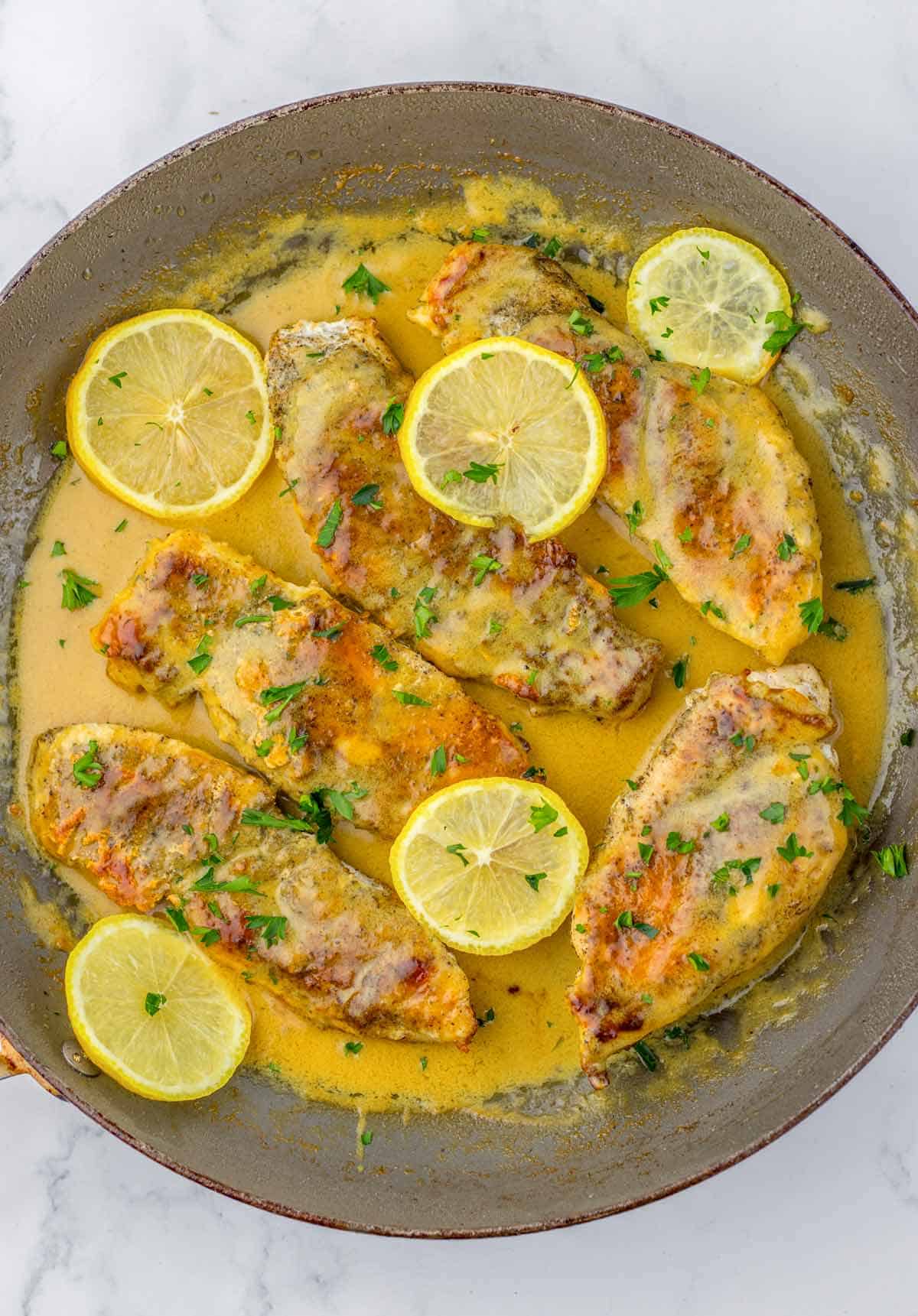 skillet with lemon butter chicken breasts.