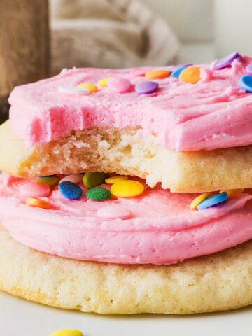 a stack of pink frosted sugar cookies.