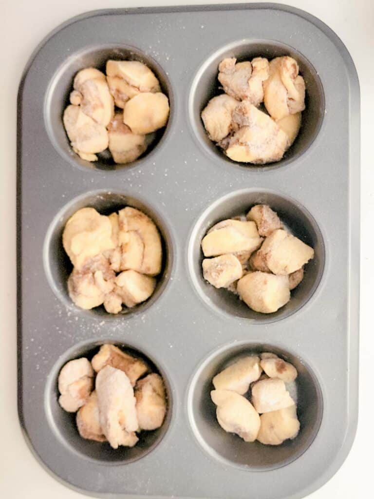 cinnamon roll pieces arranged in muffin tins.