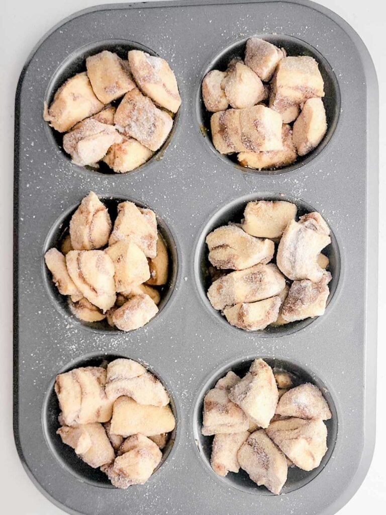 cinnamon roll pieces arranged in muffin tins.