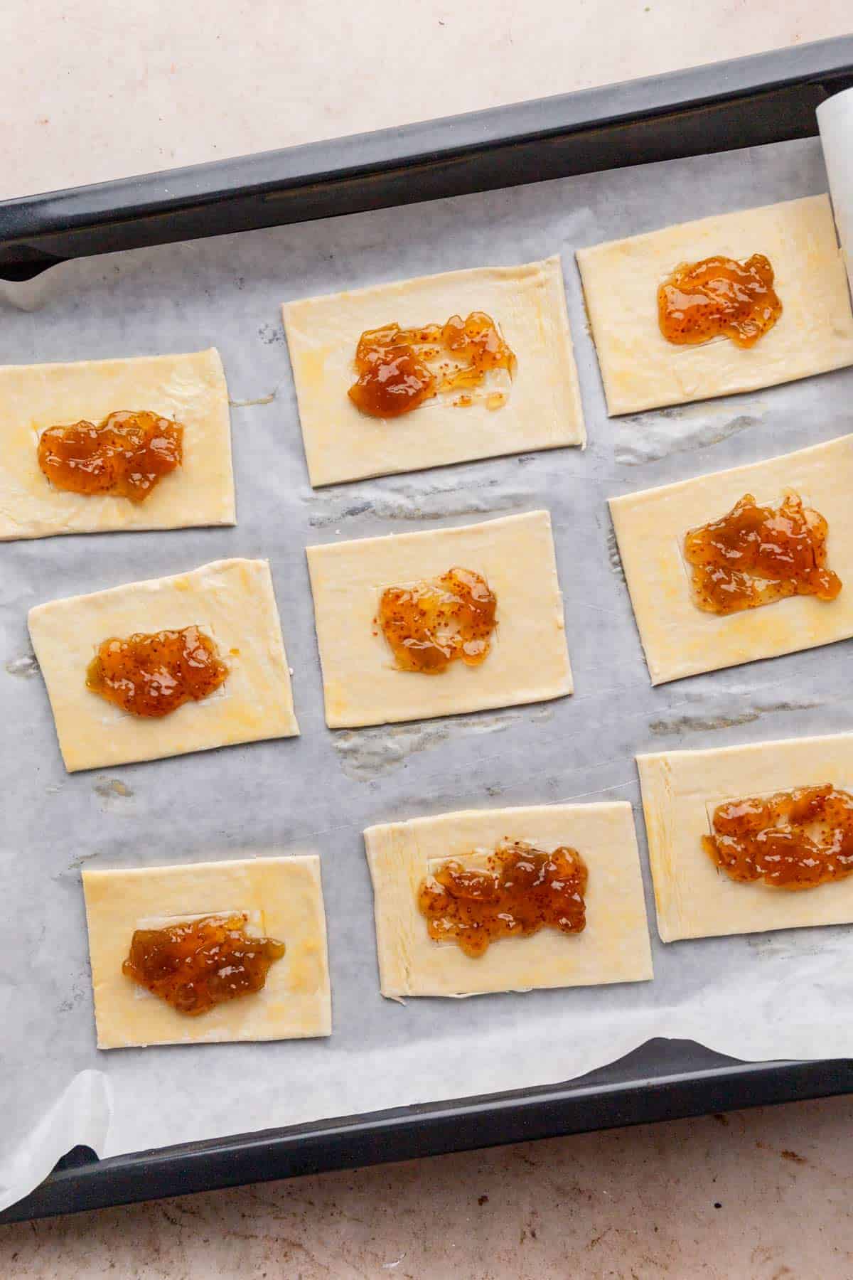 adding fig jam to puff pastry.