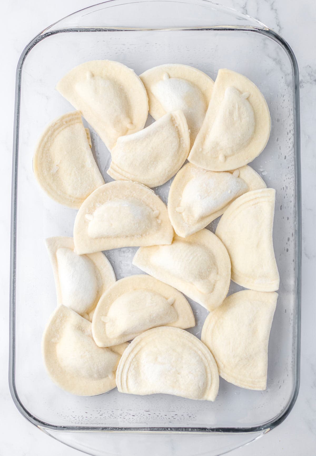 frozen pierogis in casserole dish.