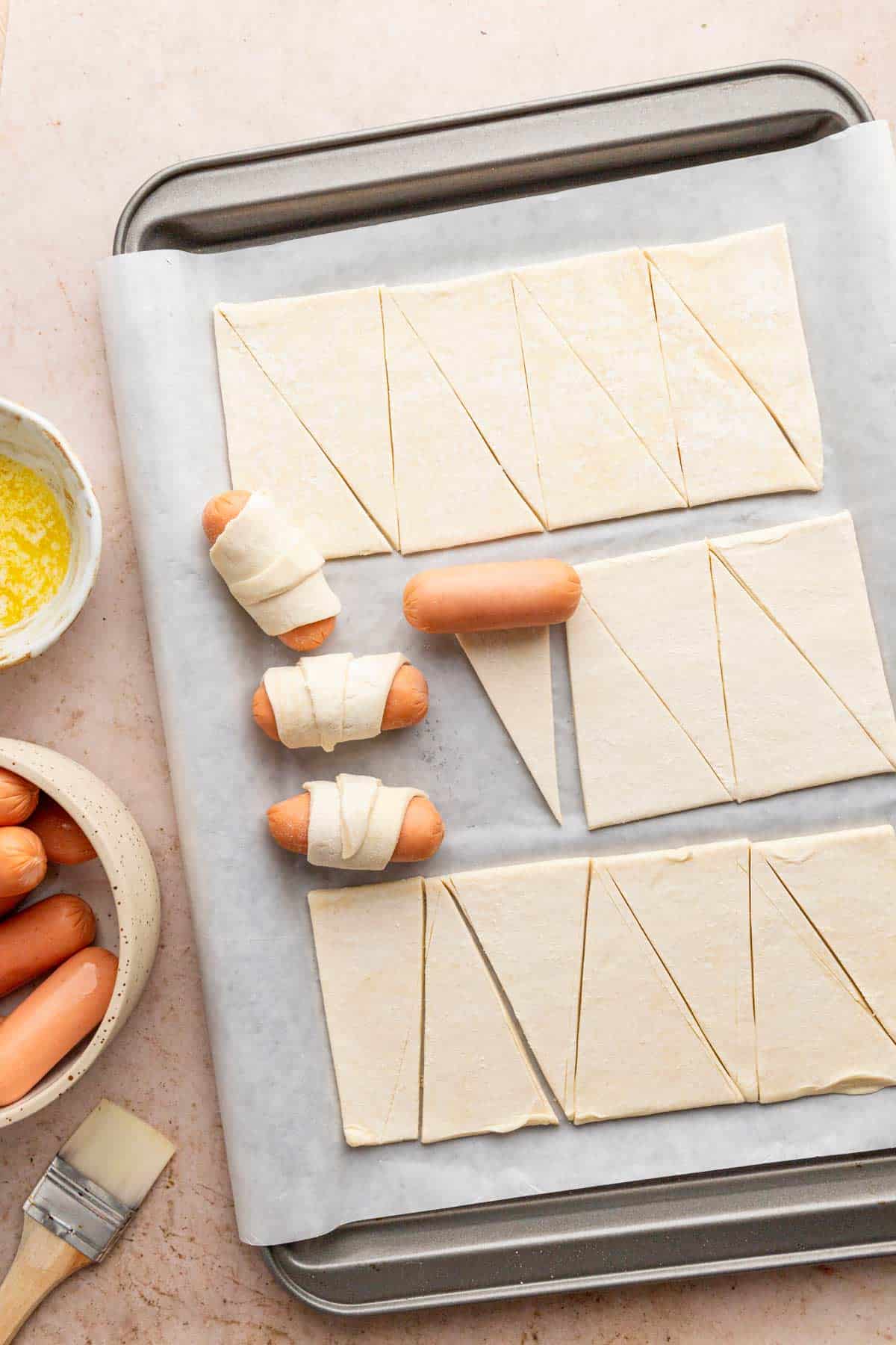 wrapping sausages in puff pastry sheets.