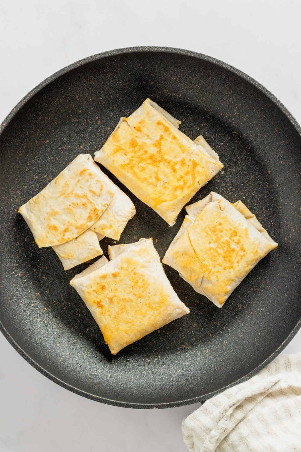 frying the folded wraps in skillet.