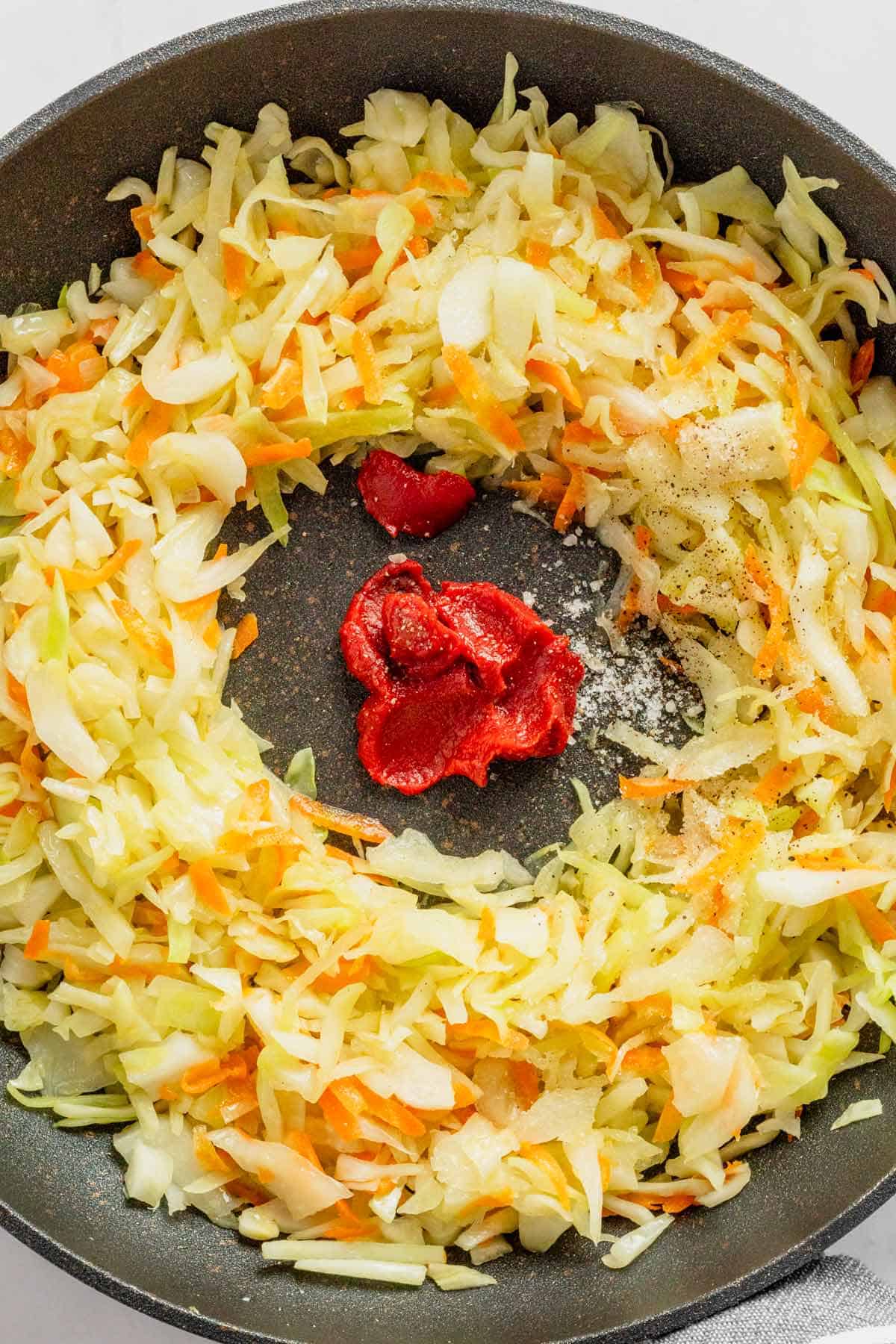 tomato paste added to skillet with cabbage/