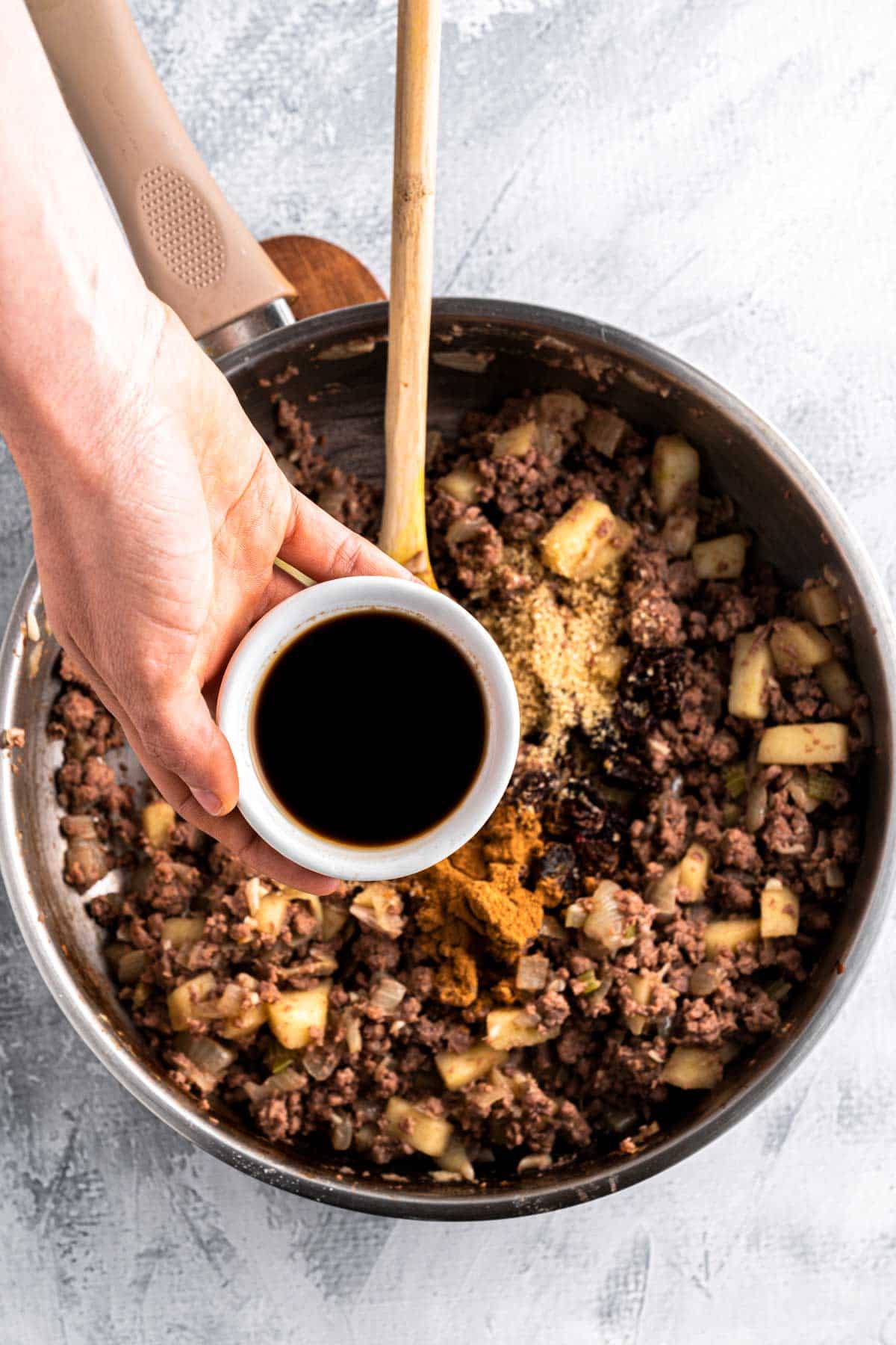 adding dark sauce to beef mixture.