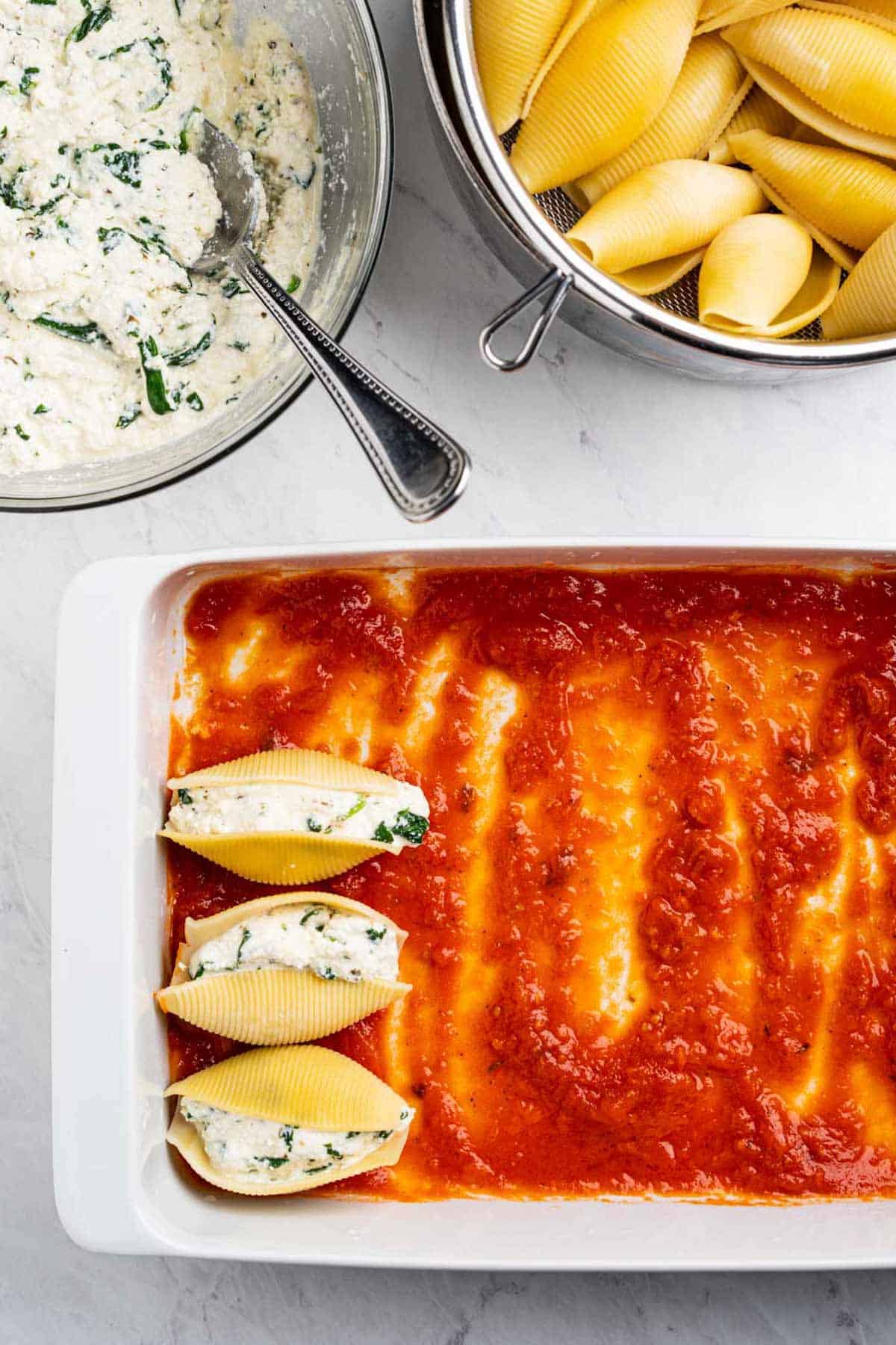 arranging stuffed shells in baking dish.