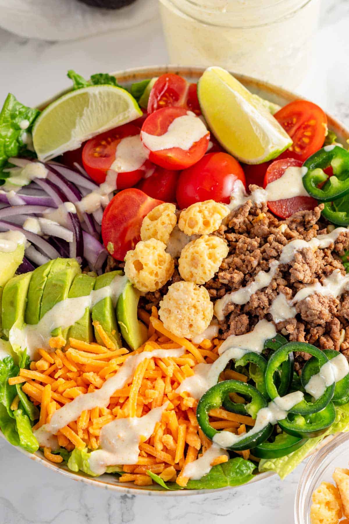 assembled taco salad with white dressing.