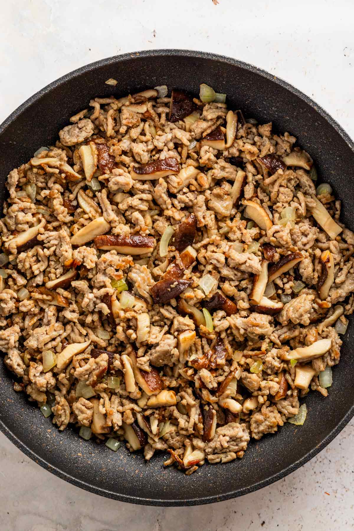 ground pork and shiitake mushrooms in skillet.