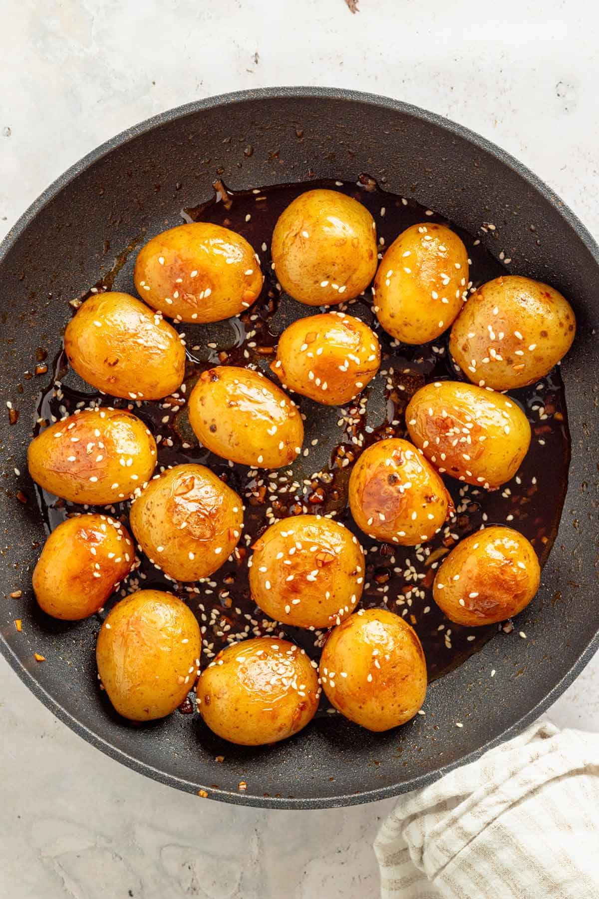 baby potatoes in dark sauce and sesame seeds.