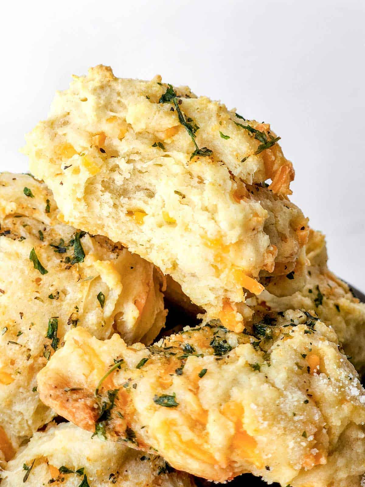 cheddar biscuits in a bowl with garlic butter.